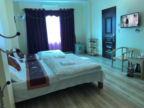 a bedroom with a large bed and a window at Kien Thao Hotel in Ha Giang
