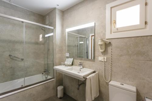 
a bathroom with a toilet, sink, and shower at Hotel Comfort Dauro 2 in Granada
