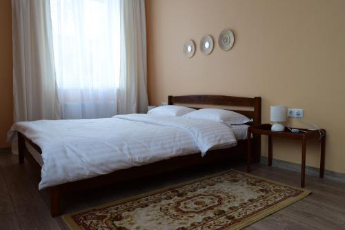 - une chambre avec un lit doté de draps blancs et d'un tapis dans l'établissement Central comfortable one-bedroom apartment, à Chişinău