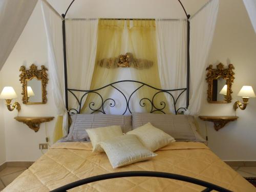 a bedroom with a canopy bed with two mirrors at Valverde Guest House in Tarquinia