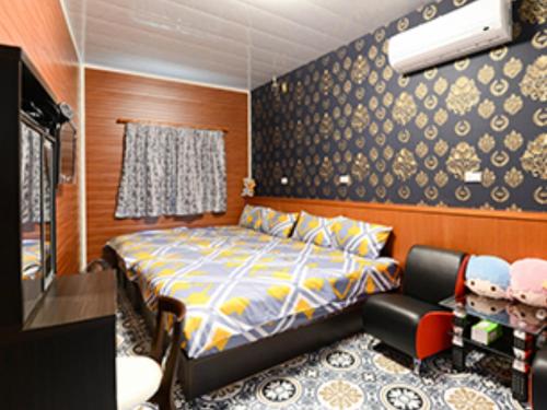 1 dormitorio con 1 cama y 1 silla en Full House B&B, en Xiaoliuqiu
