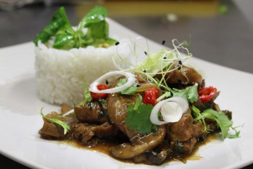 a plate of food with meat and vegetables and rice at Apartmány Caffe & Grill in Roudnice nad Labem
