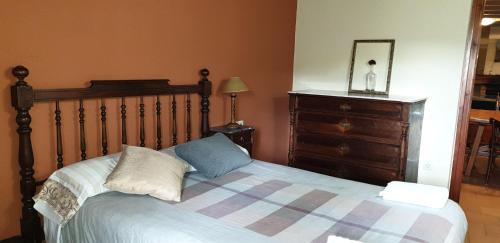 a bed with two pillows and a dresser in a bedroom at El Serrat Turisme Rural in Planoles
