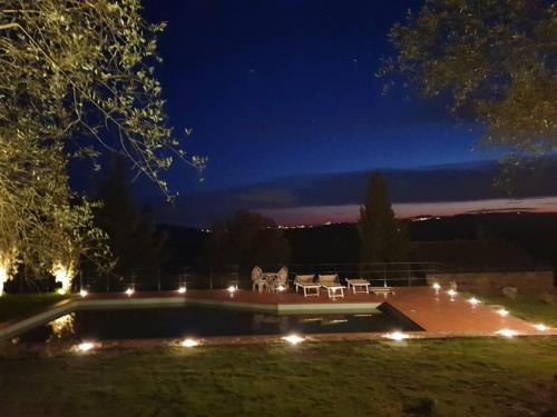 a yard with a pool at night with lights at Casa Colle Petroso in Radda in Chianti