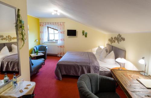 a hotel room with two beds and a table at Hotel & Ferienwohnungen Bohlenblick in Saalfeld