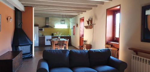 a living room with a blue couch and a kitchen at El Serrat Turisme Rural in Planoles