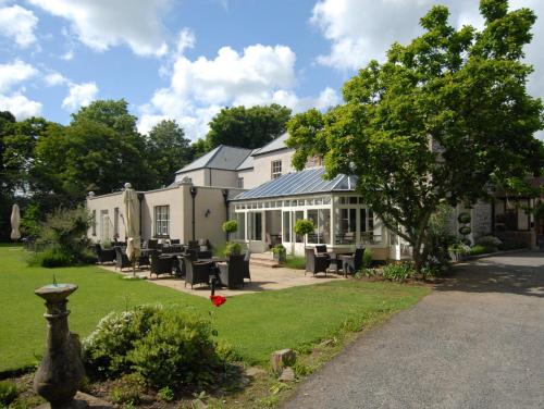 a house with a patio and a yard at Hartnoll Hotel & Spa in Tiverton
