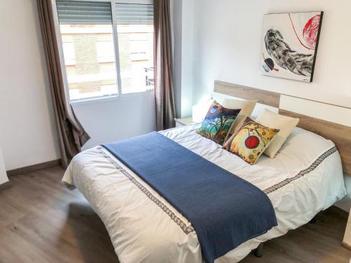 - une chambre avec un grand lit, des oreillers et une fenêtre dans l'établissement Luminoso piso + balcón en Valencia, à Valence