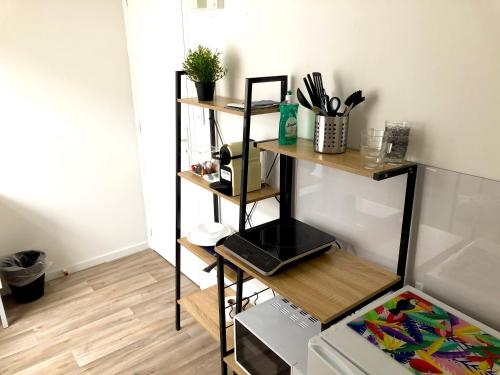 a kitchen with a shelf with a microwave and a stove at Capstay famars & Netflix in Famars
