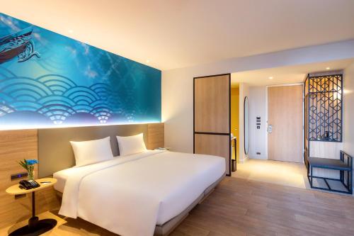 a bedroom with a white bed and a blue wall at ibis Styles Bangkok Ratchada in Bangkok