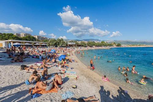 a crowded beach with people in the water at Mali apartman za veliki odmor LUDI in Split
