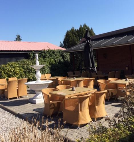a group of tables and chairs next to a fountain at Hotel Laasby Kro in Låsby