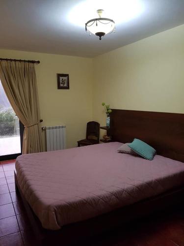 a bedroom with a large bed and a chair at Casa Dos Gaios in Vieira do Minho