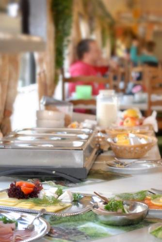 a table with plates of food on top of it at Wolkensteiner Zughotel in Wolkenstein