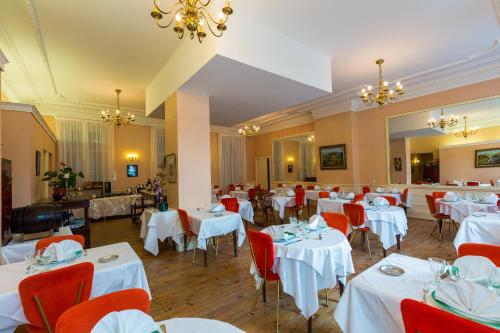 a dining room filled with tables and chairs at Le Parc Des Fees Hôtel Retaurant & Spa in La Bourboule