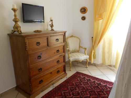 um quarto com uma cómoda e uma televisão por cima em Valverde Guest House em Tarquinia