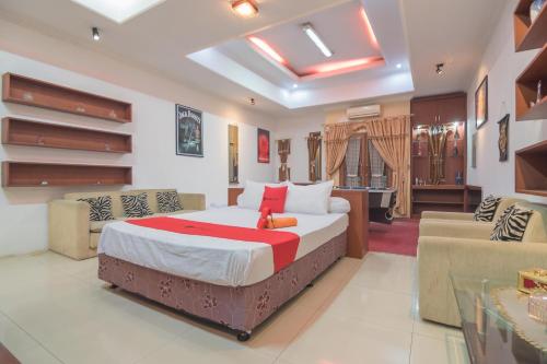 a bedroom with a bed and a living room at RedDoorz Syariah near Margahayu Raya in Bandung