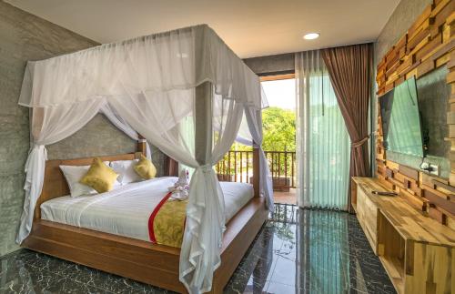 a bedroom with a canopy bed and a television at The Country Villa in Ao Nang Beach