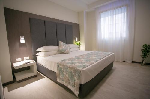 a bedroom with a large bed with a large headboard at Mosella Suite Hotel in Sottomarina