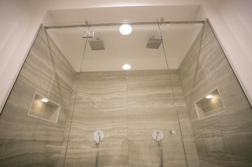 a shower with two lights on the ceiling at Mosella Suite Hotel in Sottomarina