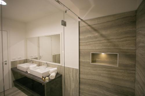 a bathroom with two sinks and a mirror at Mosella Suite Hotel in Sottomarina