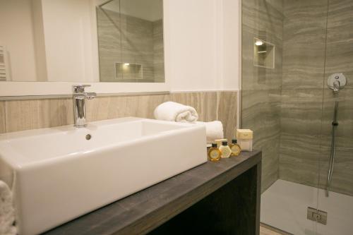 a bathroom with a white sink and a shower at Mosella Suite Hotel in Sottomarina