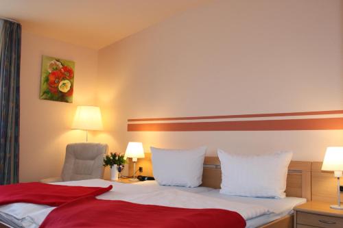 a hotel room with a bed and a chair at Spreewaldhotel Seerose in Burg
