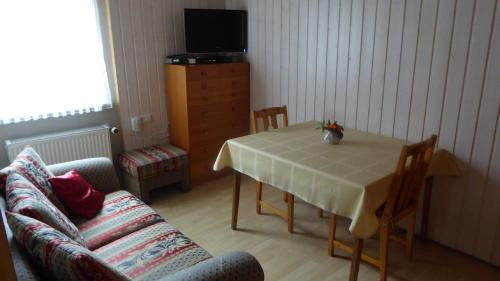 ein Wohnzimmer mit einem Tisch und einem Sofa in der Unterkunft Ferienwohnung Angelika Gries in Margetshöchheim