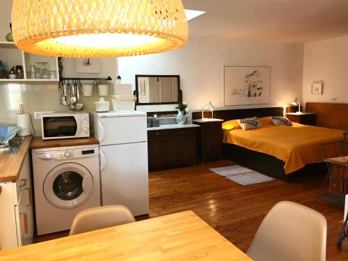 a bedroom with a bed and a kitchen with a microwave at Studio Doklestic in Dubrovnik