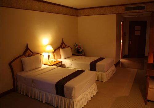 a hotel room with two beds and a lamp at JP Emerald Hotel in Yasothon