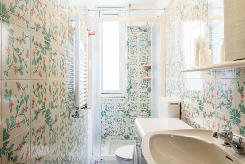 ラパッロにあるAzzurro Giuliana Apartmentの花柄の壁紙を使用したバスルーム(シンク付)