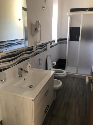a bathroom with a white sink and a toilet at Deluxe Lipari Room in Lipari