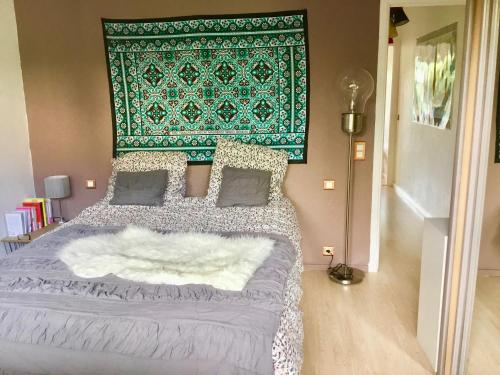 マンドリュー・ラ・ナプールにあるGrand 2 pièces plain pied avec jardin et terrasseの緑の壁のベッドルーム1室(大型ベッド1台付)