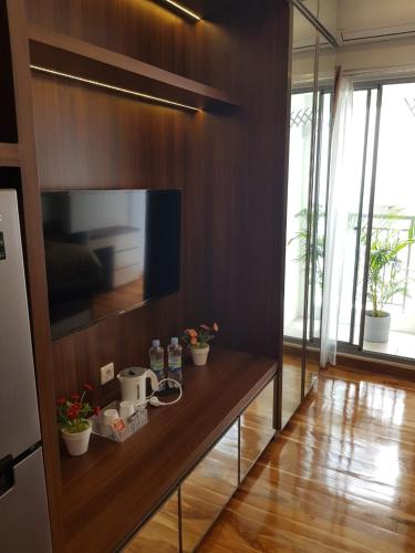 a living room with a television on a wooden wall at M-Town Residence Gading Serpong by J`s Luxury Apartment in Tangerang