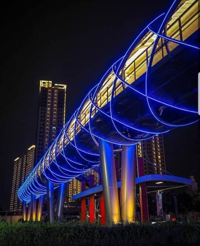 a blue structure with lights on a building at night at M-Town Residence Gading Serpong by J`s Luxury Apartment in Tangerang