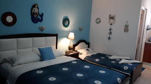 a bedroom with a bed and a blue wall at House Stella Tasos in Sarti