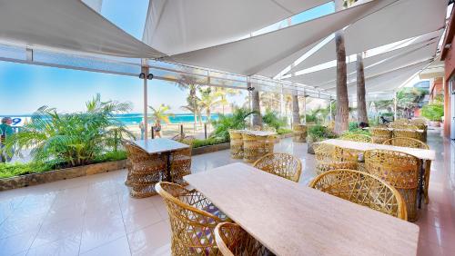 a restaurant with tables and chairs and a view of the ocean at Bull Reina Isabel & SPA in Las Palmas de Gran Canaria