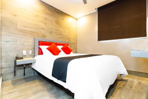 a bedroom with a large white bed with red pillows at Hotel Sonora, Centro Histórico in Mexico City