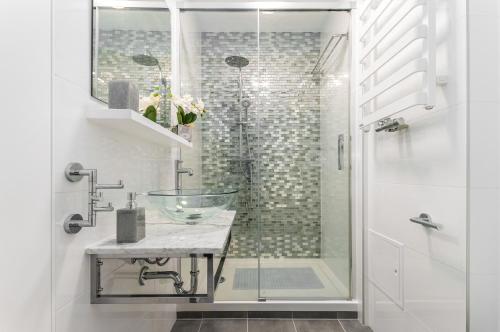 ein Badezimmer mit einem Glaswaschbecken und einer Dusche in der Unterkunft Apartments Golden Warsaw by Renters in Warschau
