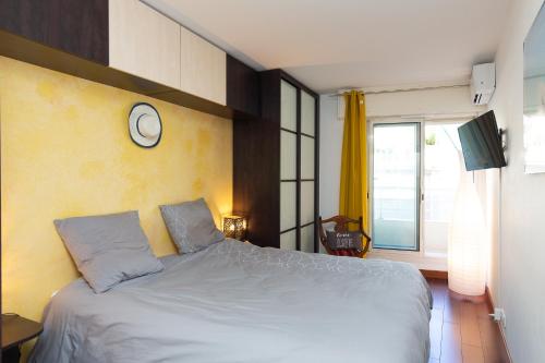 - une chambre dotée d'un lit avec une horloge murale dans l'établissement Villa AD’ALTA, à Cannes