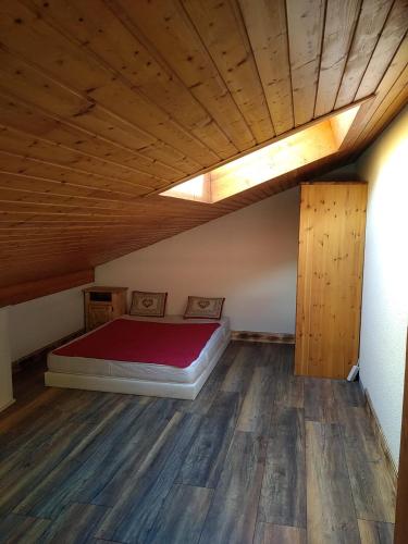 une chambre avec un lit et un parquet dans l'établissement Le Nant, aux Contamines-Montjoie