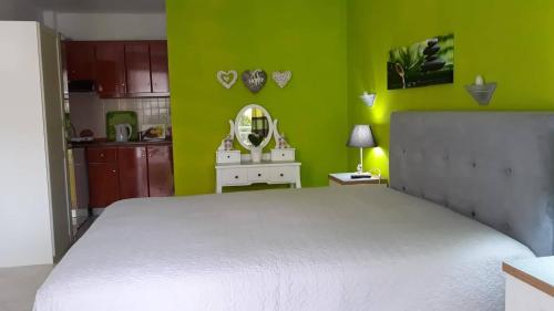 a bedroom with a white bed and a green wall at House Stella Tasos in Sarti