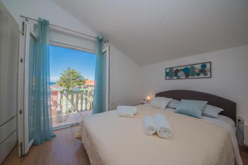 een slaapkamer met een groot bed en handdoeken bij Apartment Prominac in Zadar