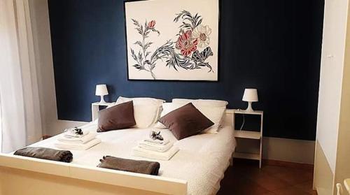 ein Schlafzimmer mit einem weißen Bett und einem Gemälde an der Wand in der Unterkunft The holiday house in Santeramo in Colle