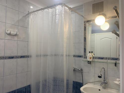 a bathroom with a shower curtain and a sink at Barbara Vendégház in Balatonfüred