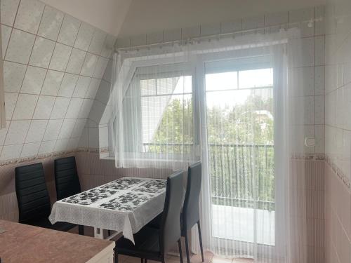 a dining room with a table and a window at Barbara Vendégház in Balatonfüred
