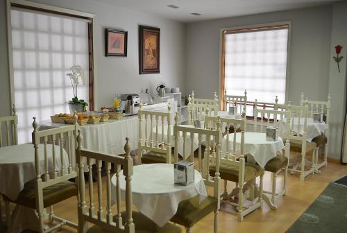 a room with tables and chairs with white table cloth at Hotel Tres Carabelas in Baiona