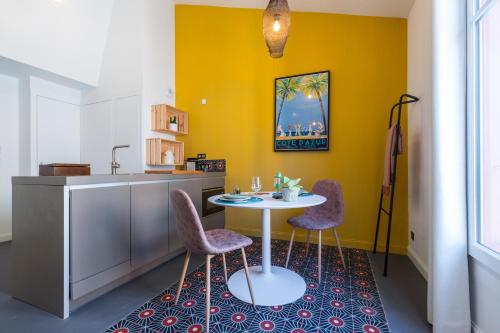 a kitchen with a table and two chairs at L'Abeille - Boutique Apartments in Nice