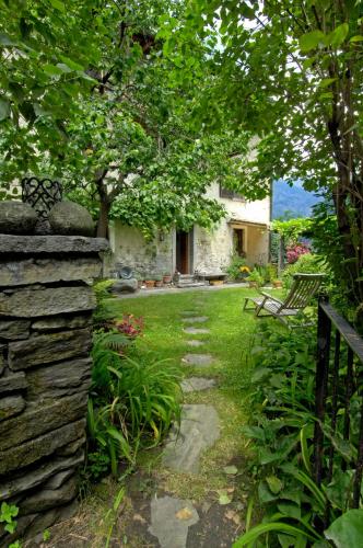 a garden with a stone wall and a tree at Pensione Boschetto in Cevio