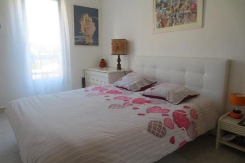 une chambre avec un lit avec des coeurs roses dessus dans l'établissement COSTEBELLE Appartement entier, à Hyères